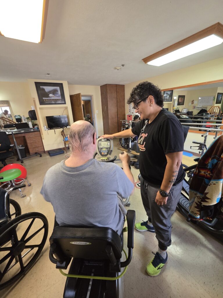 Malissa Sanchez helping a therapy patient on a bike
