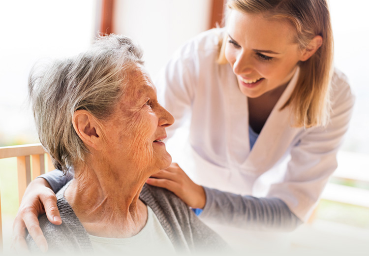 Female medical practitioner smiling at elderly woman sitting