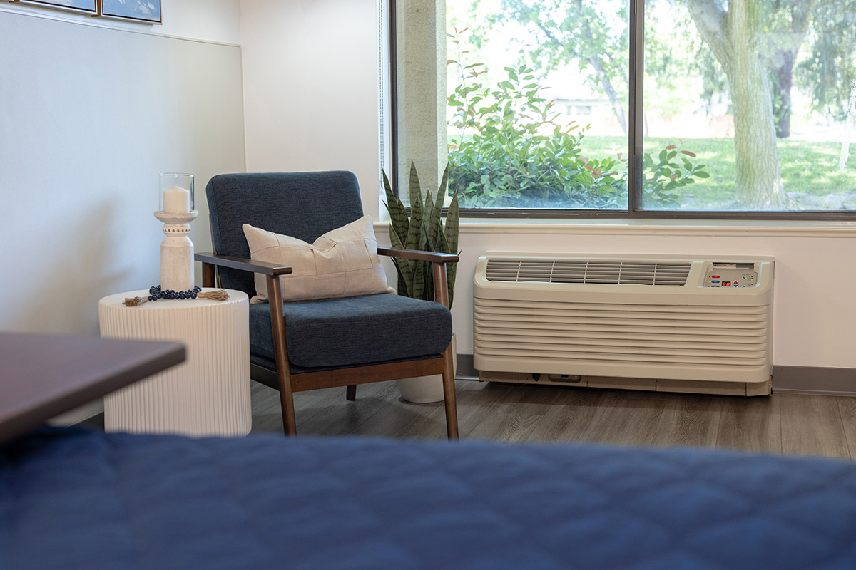 A resident's bedside next to a chair and window at Sunnyvale Gardens