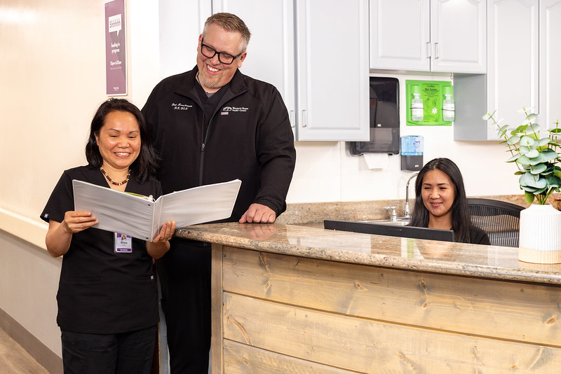 nursing care Nurses reading binder at front desk of Western Slope