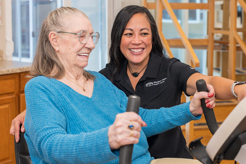 Physical therapist helping patient turn on a therapy bike
