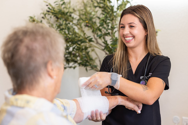 Nurse wrapping arm of patient with gauze