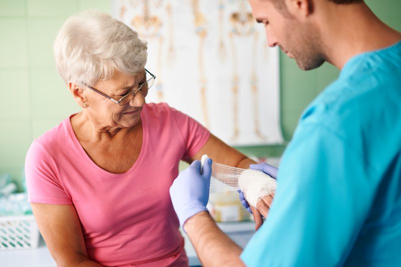 Nurse wrapping the hand of a patient with gauze