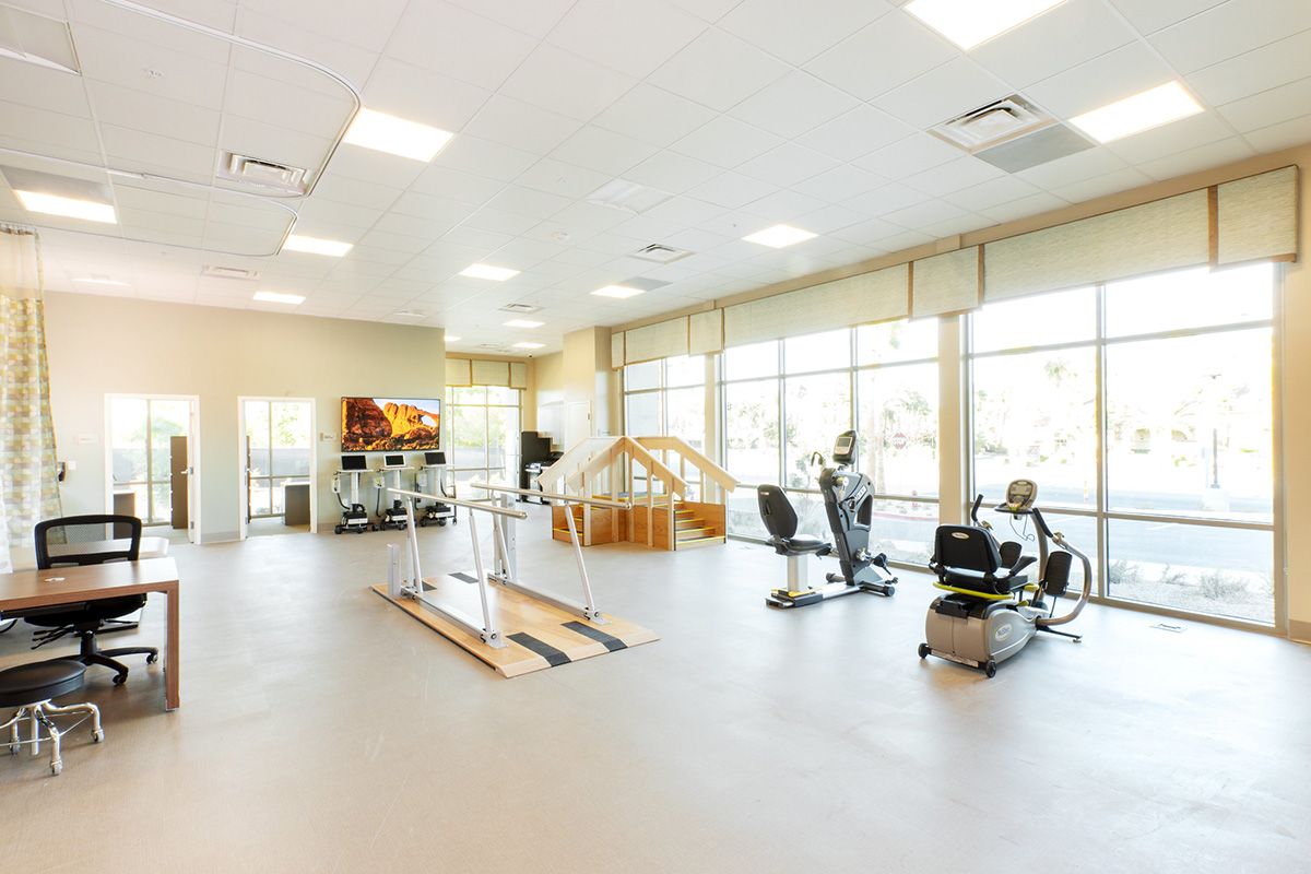 A rehab therapist with an elderly woman in the rehab gym