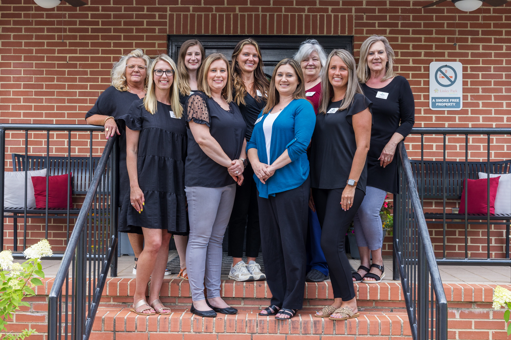linley-park-admin Nine administrators posing on stairs in front of Linley Park