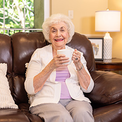 An elderly woman holding a mug